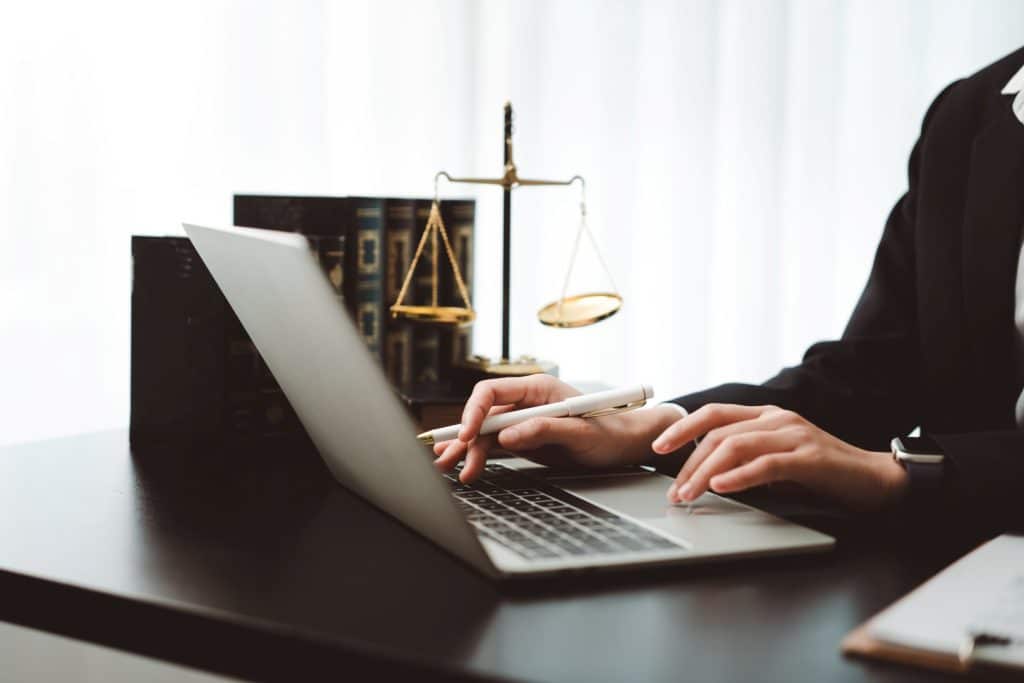 closeup of hands typing up letter of termination on laptop