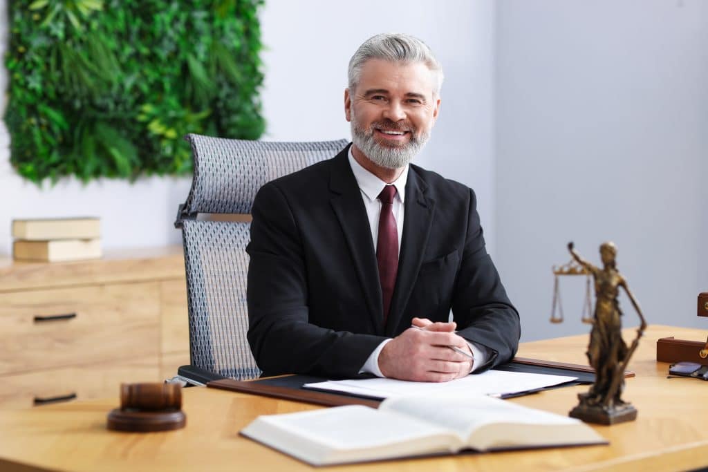 portrait of smiling lawyer sitting behind desk